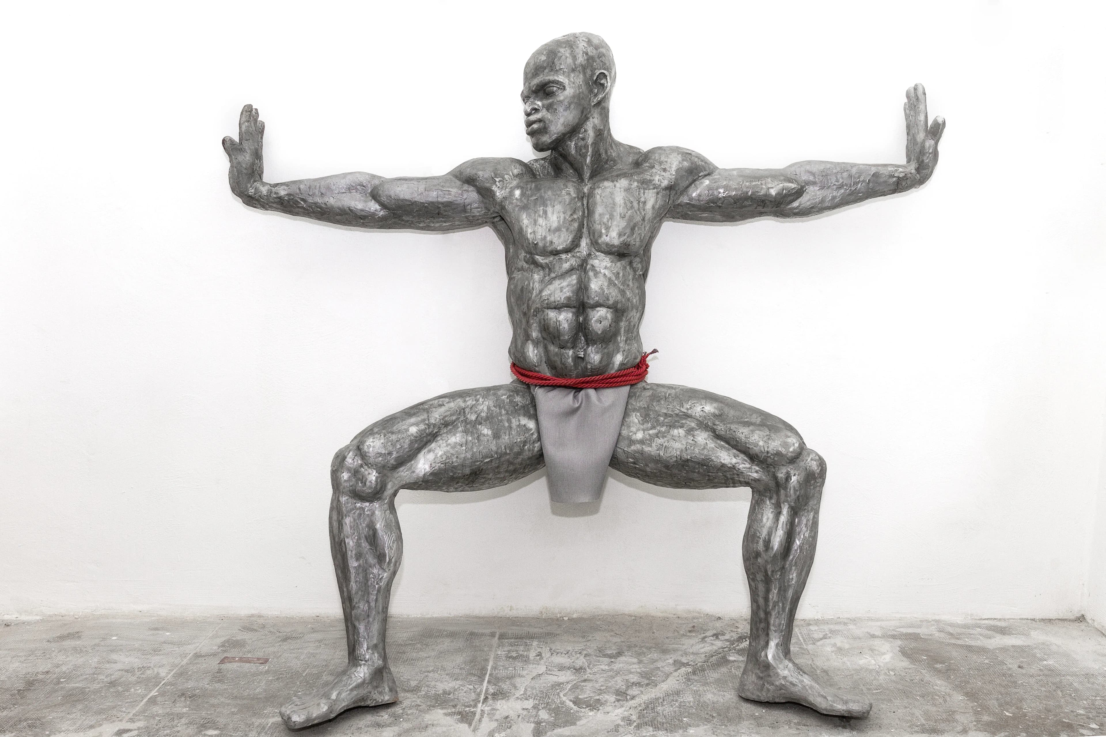 Infinity: a 218 cm tall aluminium sculpture of a Nigerian man crouching with hands outstretched
