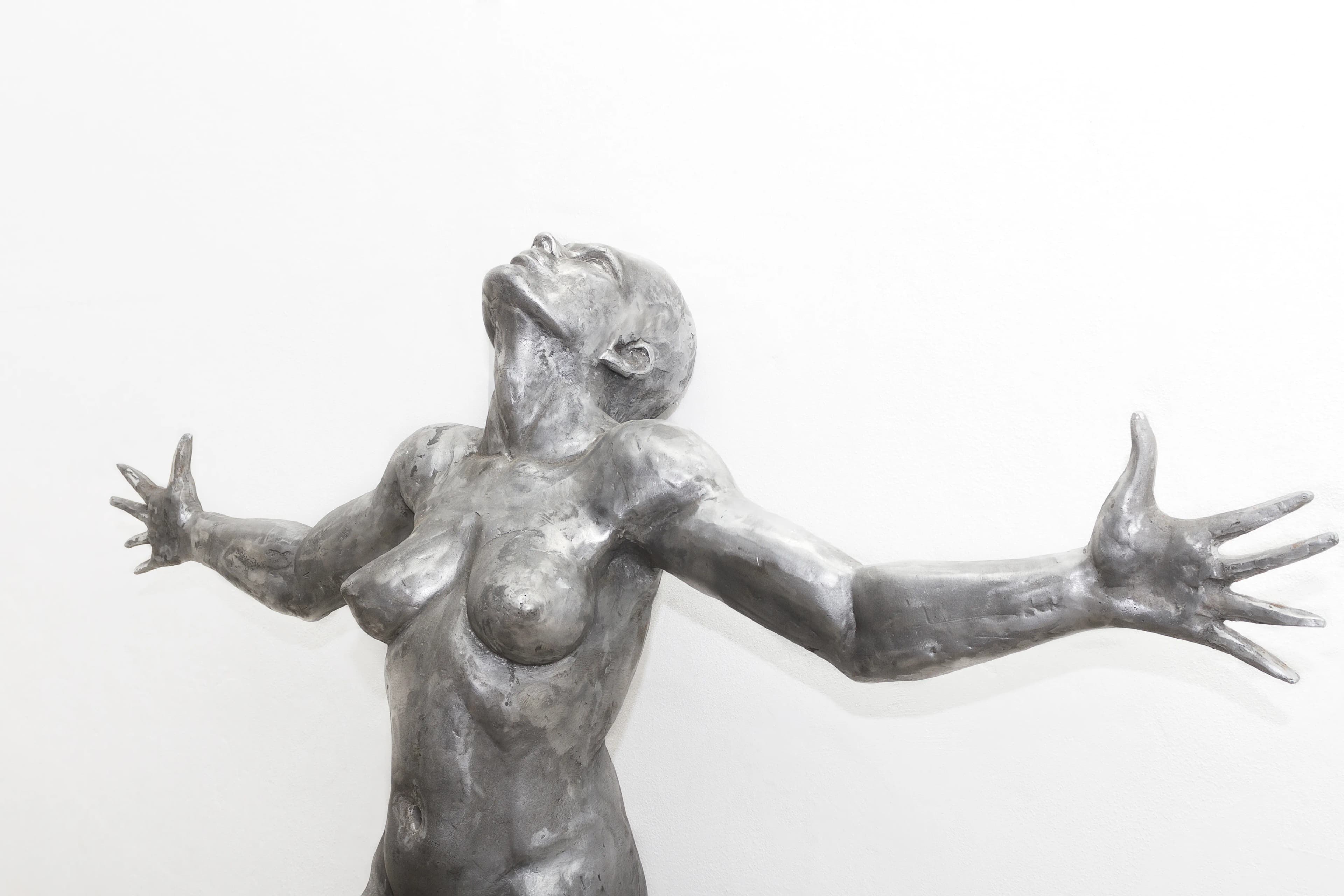 Sacrifice: a 186cm tall aluminium sculpture of a strong, beautiful woman with her hands outstretched